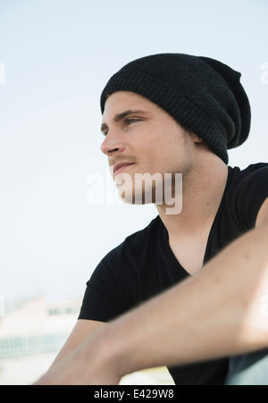 Portrait of young man wearing black tshirt and knit hat