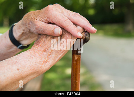 Senior woman's hands, holding walking stick Stock Photo