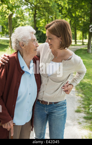 Senior woman and granddaughter standing in park Stock Photo