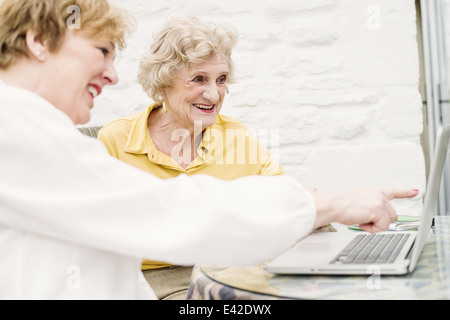 Senior woman and daughter looking at laptop