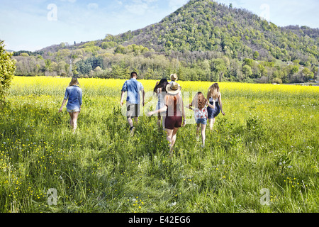 Group of friends walking in field Stock Photo
