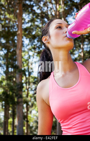 Female jogger drinking from water bottle Stock Photo