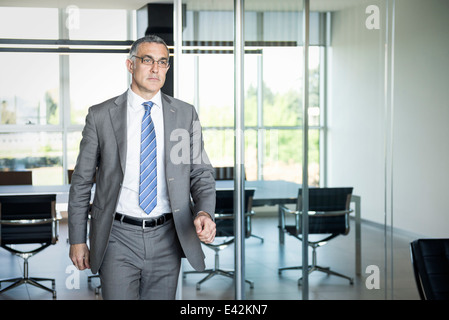 Businessman exiting meeting room Stock Photo