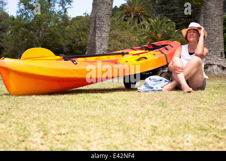 Senior woman sitting cross legged on beach Stock Photo