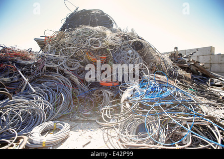 Heap of coiled and tangled cables in scrap metal yard Stock Photo