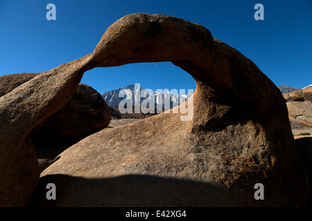 Lone Pine Peak seen through Mobius Arch in California's Alabama Hills State Recreation Area at night. Stock Photo