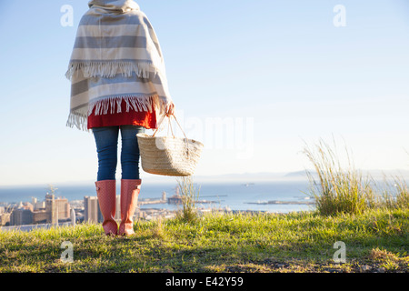 Rear view of young woman on hill with a sea view Stock Photo
