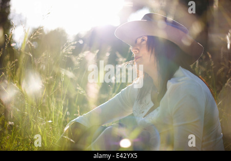 Mature woman in cowboy hat with blade of grass in her mouth Stock Photo