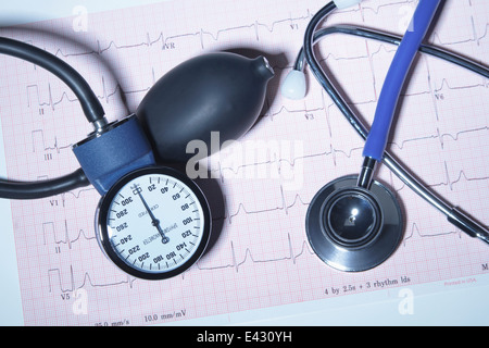 Acoustic stethoscope and blood pressure gauge on an electrocardiogram printout