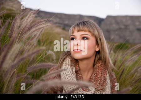 Portrait of beautiful young woman gazing from marsh grasses Stock Photo