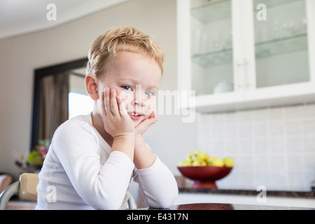 Portrait of cheeky four year old boy in kitchen Stock Photo
