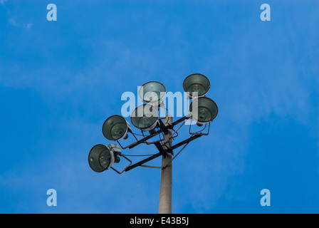 Set of six stadium floodlights on tower against blue sky. Stock Photo