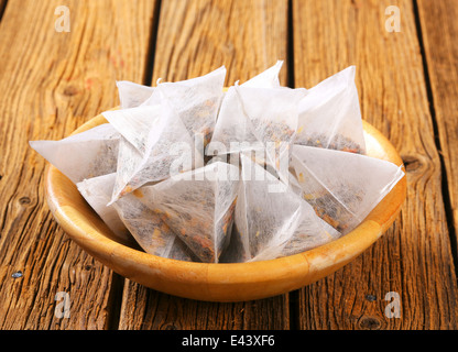 Pyramid-shaped jasmine tea bags in wooden bowl Stock Photo