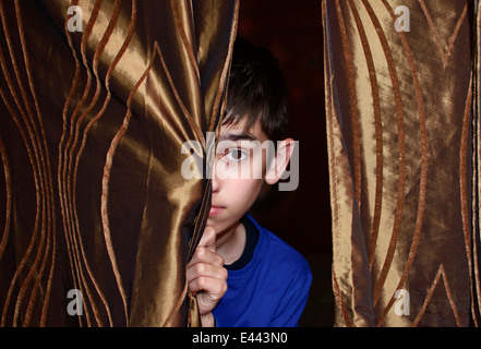 Boy is behind the curtain Stock Photo