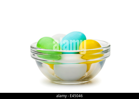 Little colored sugar and chocolate eggs in a transparent glass cup for easter celebration Stock Photo