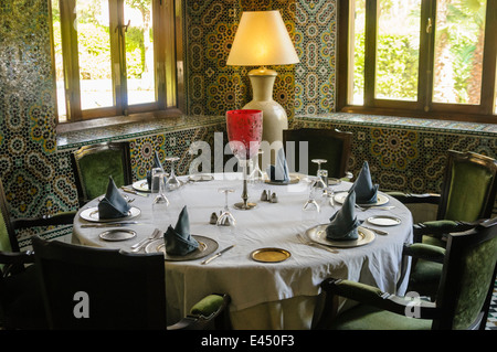 Restaurant tables against walls with ornate ceramic tiles, Red House Riad, Marrakech, Morocco Stock Photo