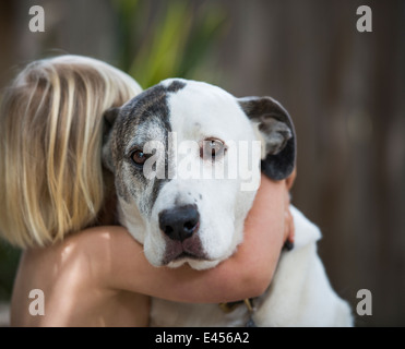 Portrait of sad looking dog hugged by three year old boy Stock Photo