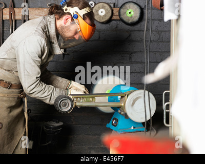 Blacksmith working on machine in workshop Stock Photo