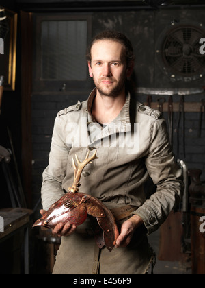 Portrait of blacksmith with a copper deer sculpture Stock Photo