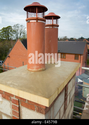 self building house, two traditional clay chimney pots with bird guard cage cowls Stock Photo