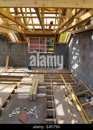 self building house, upper floor with traditional wooden joists and prefabricated roof trusses before flooring Stock Photo