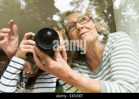 Grandmother teaching granddaughter camera usage Stock Photo