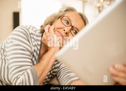 Senior woman reading using digital tablet Stock Photo