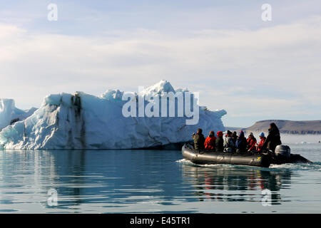Tourists in a Zodiac rib, observing an iceberg near  Devon Island, Nunavut, Canada, August 2010 Stock Photo