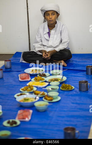 Bangkok, Thailand. 3rd July, 2014. A boy waits to eat before Iftar, the meal that breaks the day long fast at Haroon Mosque in Bangkok during the holy month of Ramadan. Ramadan is the ninth month of the Islamic calendar, and the month in which Muslims believe the Quran was revealed. The month is spent by Muslims fasting during the daylight hours from dawn to sunset. Fasting during the month of Ramadan is one of the Five Pillars of Islam. Credit:  ZUMA Press, Inc./Alamy Live News Stock Photo