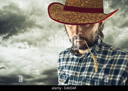 Male Farmer with cowboy straw hat in golden wheat field examining Stock ...