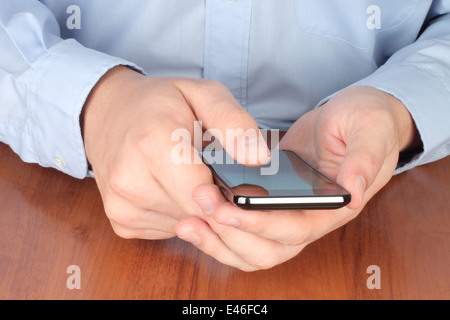 Businessman touching smart phone at the table Stock Photo