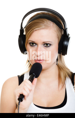 blonde girl singer performer musician singing a song to microphone isolated on white. young rockstar with headphones. Stock Photo