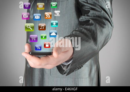 Man uses smart phone with icons on grey background Stock Photo