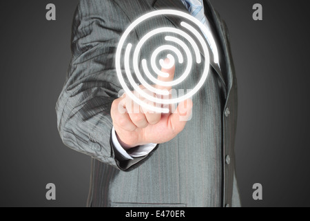 Businessman with hand using virtual inteface on dark background Stock Photo