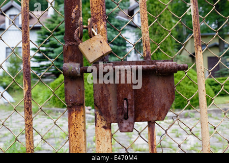 The old thrown country house is closed on rusty locks. Selective art focus Stock Photo