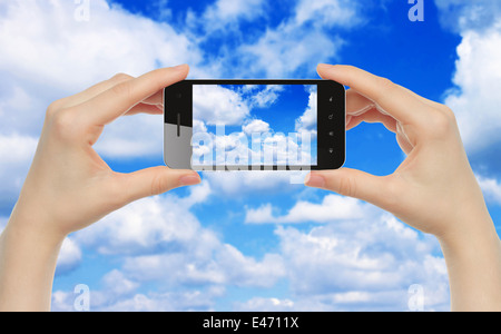 Woman hands hold smart phone with sky close-up Stock Photo