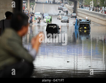 Taiyuan, China's Shanxi Province. 4th July, 2014. Vehicles are trapped on a flooded street in Taiyuan, capital of north China's Shanxi Province, July 4, 2014. Rainstorms hit the city on Friday, flooding streets and causing traffic interruptions. Credit:  Yan Yan/Xinhua/Alamy Live News Stock Photo