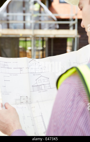 Architect Studying Plans On Building Site Stock Photo
