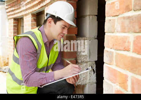 Architect Checking Insulation During House Construction Stock Photo
