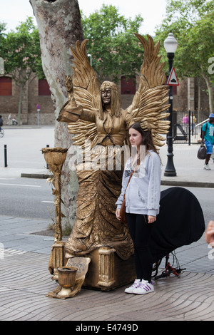 Street mime artist as an angel with girl, performing on La Rambla in Barcelona, Catalonia, Spain. Stock Photo