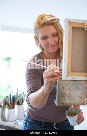 Female Artist Painting In Studio Stock Photo