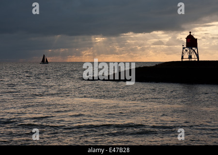 Sailing ship leaving a dutch harbor in the evening Stock Photo