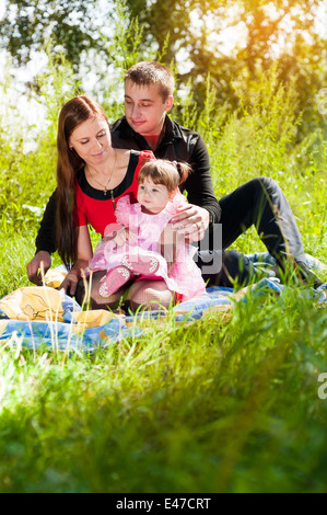 Happy family outdoor - mother, father and daughter Stock Photo
