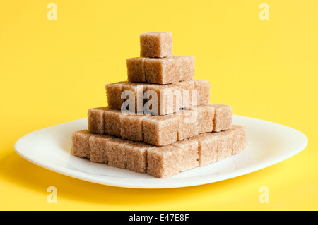 unrefined lump pieces white yellow pyramid plate backgrounds beige bowl breakfast brown candy cane ceramic clay color crystal cu Stock Photo