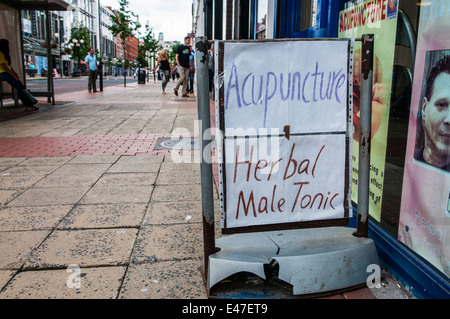 Sign outside a Chinese Health shop advertising acupuncture and herbal male tonic. Stock Photo