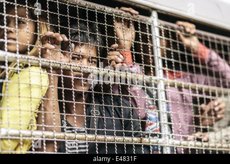 June 16, 2014 - Aranyaprathet/Poipet, Sa Kaeo Province, Thailand - Migrant Cambodians working in Thailand are transferred to the border by Immigration Police before they return home during a mass exodus, Aranyaprathet Town Centre, Aranyaprathet/Poipet, Thailand. Fearing a crackdown on illegal immigration from the Thai military, over 120,000 Cambodian migrants are reported to have crossed the border and returned to Cambodia in one week. Estimates suggest that at least 150,000 legal and illegal migrants from Cambodia were working in Thailand before the exodus, typically in the construction and s Stock Photo