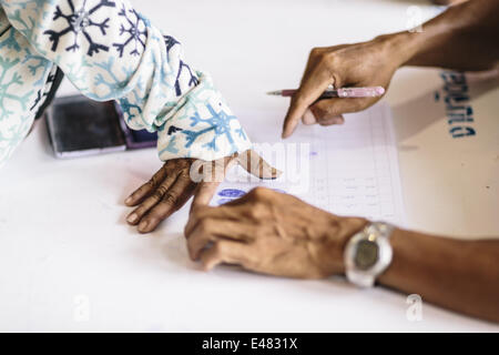 June 16, 2014 - Aranyaprathet/Poipet, Sa Kaeo Province, Thailand - Migrant Cambodian workers register their names and leave their fingerprints with Thai military personnel before they are transported to the border and return home during a mass exodus of Cambodian immigrants from Thailand, Aranyaprathet Town Centre, Aranyaprathet/Poipet, Thailand. Fearing a crackdown on illegal immigration from the Thai military, over 120,000 Cambodian migrants are reported to have crossed the border and returned to Cambodia in one week. Estimates suggest that at least 150,000 legal and illegal migrants from Ca Stock Photo