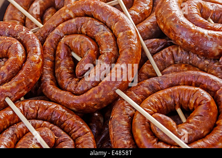 Sausages roll in bulk, fixed with wooden rods. Stock Photo