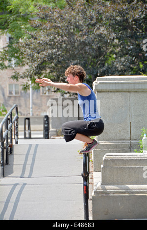 A young French visitor to New York practicing parkour at the foot of the Williamsburg Bridge in Brooklyn, New York Stock Photo
