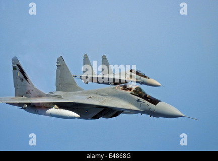 A Royal Malaysian Air Force MiG-29N Interceptor and Su-30MKM multirole fighter fly in wingtip formation during a joint patrol with the George Washington Carrier Strike Group June 24, 2014 off the coast of Malaysia. Stock Photo